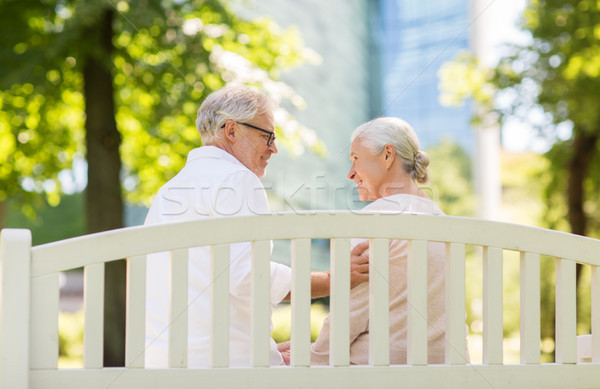 happy senior couple sitting on bench at park Stock photo © dolgachov