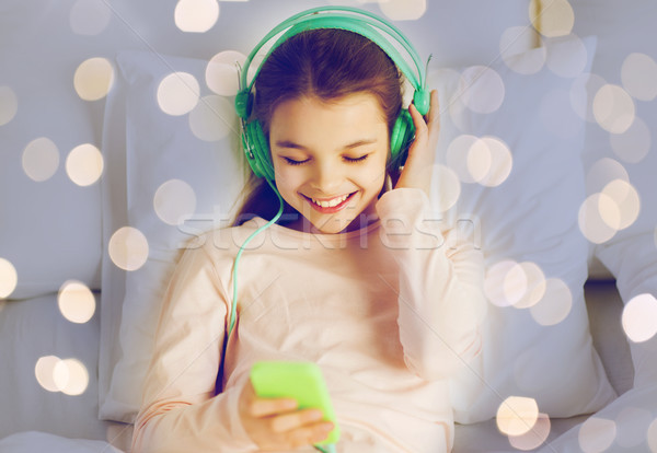 Mädchen Kopfhörer Musik hören Bett Menschen Kinder Stock foto © dolgachov