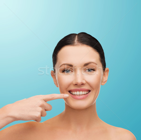 young calm woman pointing to her mouth Stock photo © dolgachov
