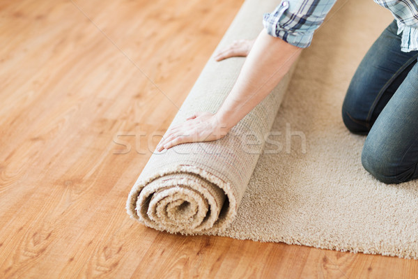 Stock photo: close up of male hands unrolling carpet