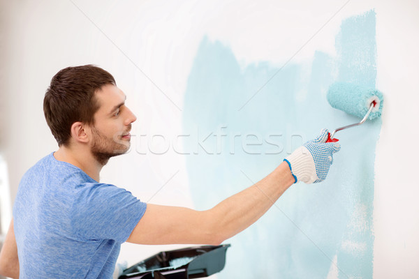 smiling man painting wall at home Stock photo © dolgachov
