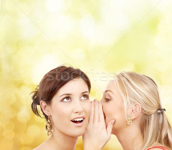 two smiling women whispering gossip Stock photo © dolgachov