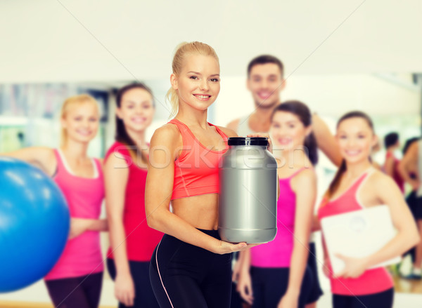 Sorridente mulher jarra proteína fitness Foto stock © dolgachov