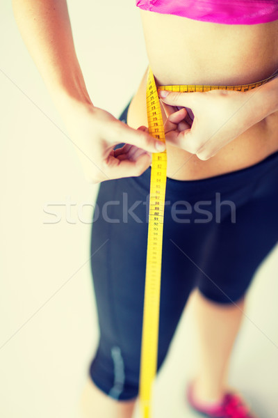 Stock photo: trained belly with measuring tape