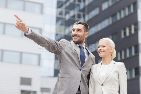 smiling businessmen standing over office building Stock photo © dolgachov