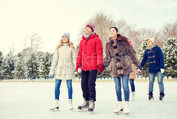 happy friends ice skating on rink outdoors Stock photo © dolgachov