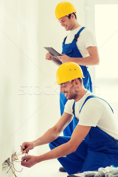builders with tablet pc and fixing wiring indoors Stock photo © dolgachov