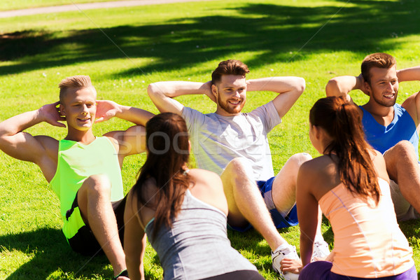 group of friends or sportsmen exercising outdoors Stock photo © dolgachov