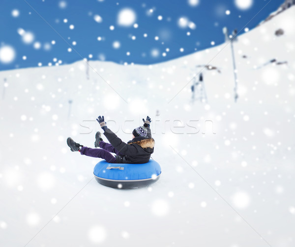 happy young man sliding down on snow tube Stock photo © dolgachov