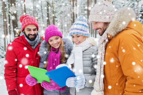smiling friends with tablet pc in winter forest Stock photo © dolgachov