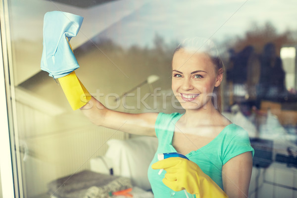 happy woman in gloves cleaning window with rag Stock photo © dolgachov