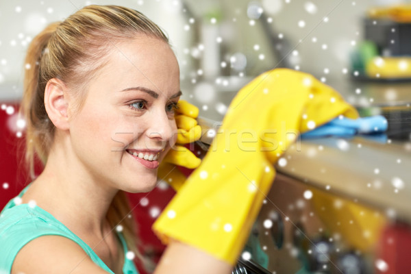 happy woman cleaning cooker at home kitchen Stock photo © dolgachov