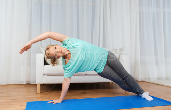 woman exercising on mat at home Stock photo © dolgachov