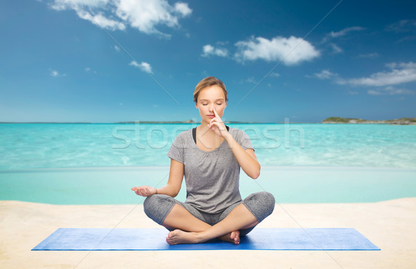 woman meditating in lotus yoga pose on beach Stock photo © dolgachov