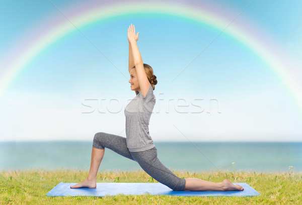 happy woman making yoga in low lunge on mat Stock photo © dolgachov