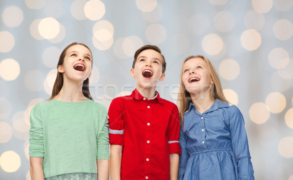 amazed boy and girls looking up Stock photo © dolgachov