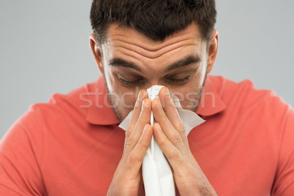 sick man blowing nose to paper napkin at home Stock photo © dolgachov