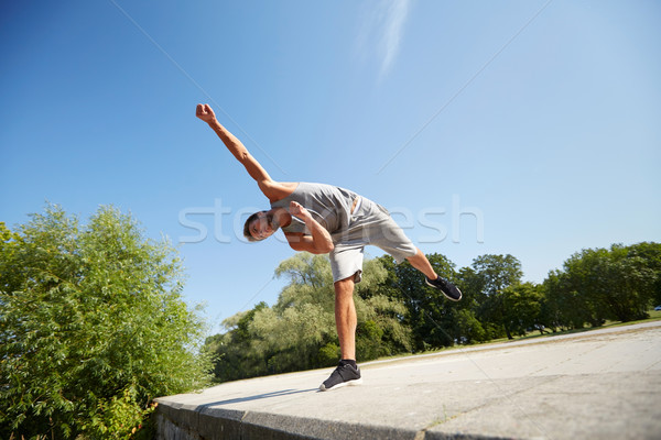 sporty young man jumping in summer park Stock photo © dolgachov