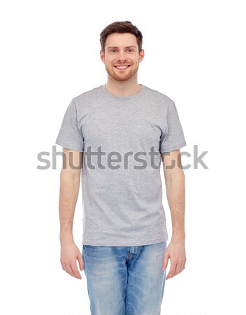 Uśmiechnięty młody człowiek szary tshirt dżinsy mężczyzna Zdjęcia stock © dolgachov