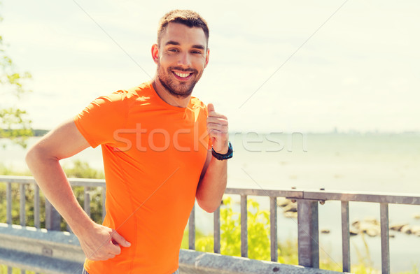 Sorridente moço corrida verão beira-mar fitness Foto stock © dolgachov