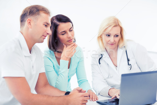 doctor with patients looking at laptop Stock photo © dolgachov