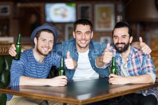 Gelukkig mannelijke vrienden drinken bier bar Stockfoto © dolgachov