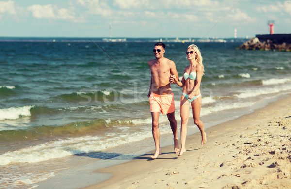 happy couple in swimwear running on summer beach Stock photo © dolgachov