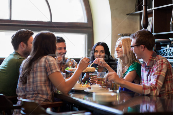 happy friends with beer eating at bar or pub Stock photo © dolgachov