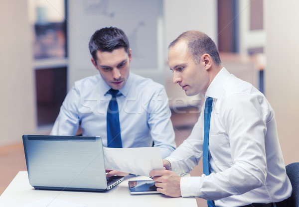 Doua oameni de afaceri discuţie birou afaceri tehnologie Imagine de stoc © dolgachov