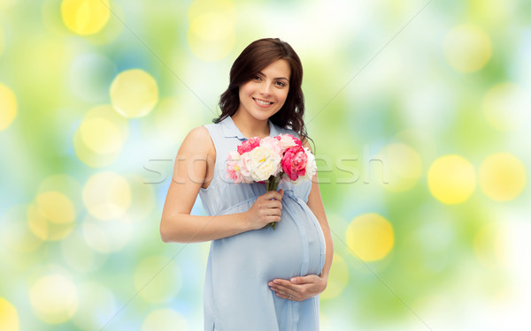 happy pregnant woman with flowers touching belly Stock photo © dolgachov