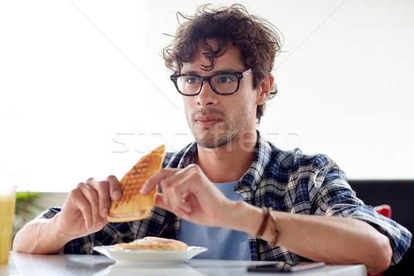 happy man eating sandwich at cafe for lunch Stock photo © dolgachov