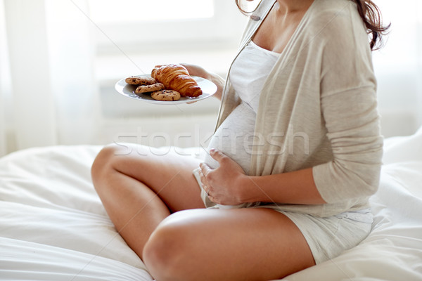 Mujer embarazada croissants casa embarazo una alimentación poco saludable Foto stock © dolgachov