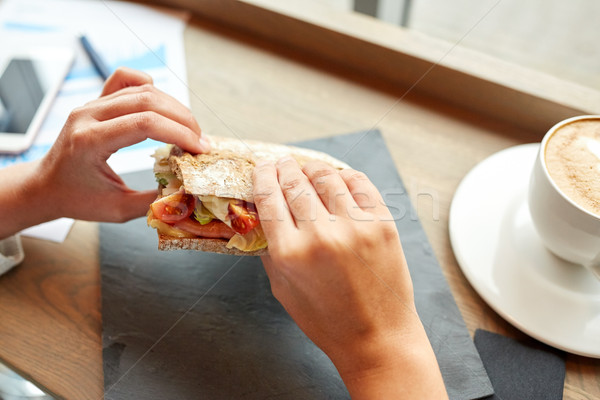 Stock photo: woman eating salmon panini sandwich at restaurant