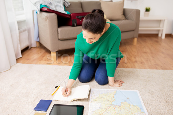 woman with notebook and travel map at home Stock photo © dolgachov