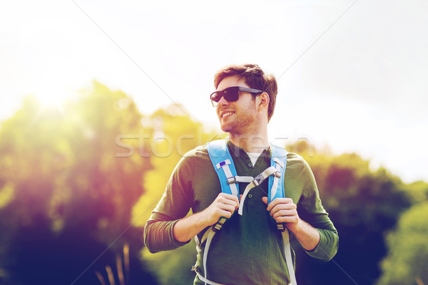 happy young man with backpack hiking outdoors Stock photo © dolgachov