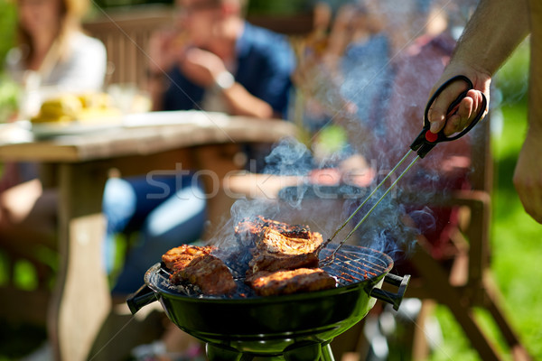 man cooking meat on barbecue grill at summer party Stock photo © dolgachov