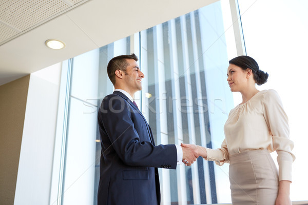 smiling business people shaking hands at office Stock photo © dolgachov