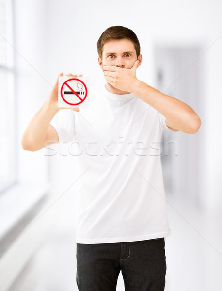 young man holding no smoking sign Stock photo © dolgachov