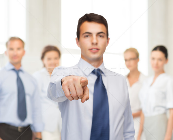 friendly young buisnessman pointing finger Stock photo © dolgachov