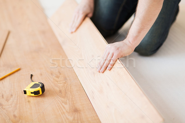 Stock photo: close up of male hands intalling wood flooring