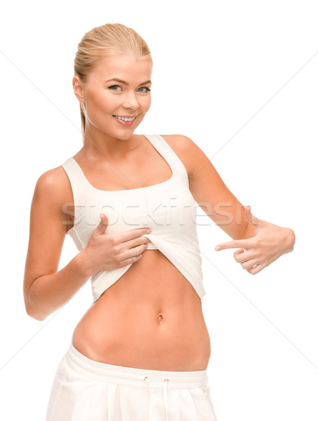 beautiful sporty woman pointing at her abs Stock photo © dolgachov