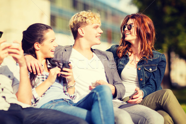 students looking at smartphones and tablet pc Stock photo © dolgachov