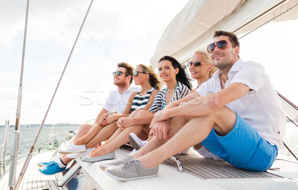 smiling friends sitting on yacht deck Stock photo © dolgachov