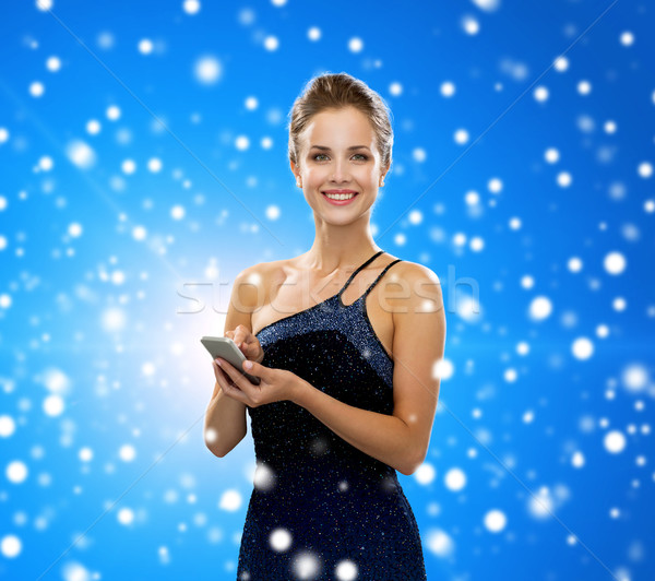 улыбающаяся женщина вечернее платье смартфон технологий связи зима Сток-фото © dolgachov
