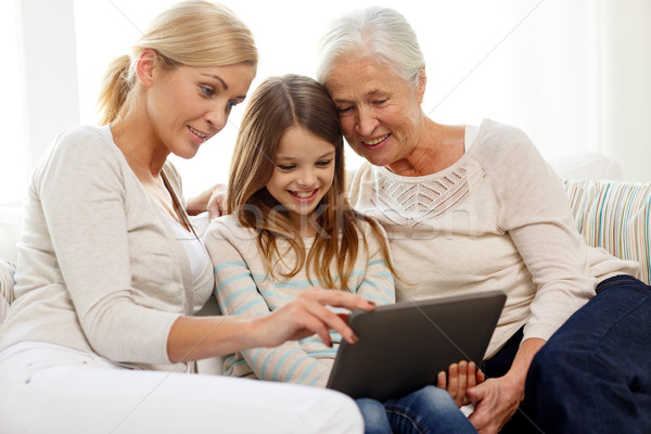 Stock photo: smiling family with tablet pc at home