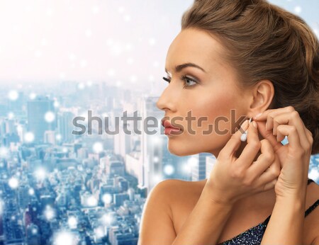 Donna indossare lucido diamante orecchini Foto d'archivio © dolgachov