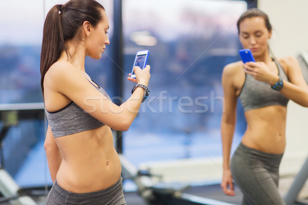 Сток-фото: женщину · смартфон · зеркало · спортзал · спорт