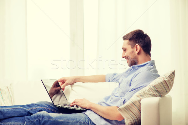 smiling man working with laptop at home Stock photo © dolgachov