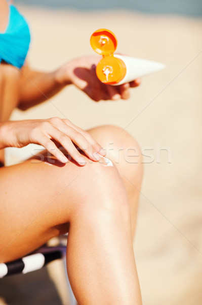 girl putting sun protection cream on beach chair Stock photo © dolgachov