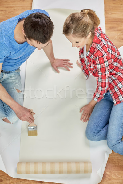 close up of couple smearing wallpaper with glue Stock photo © dolgachov